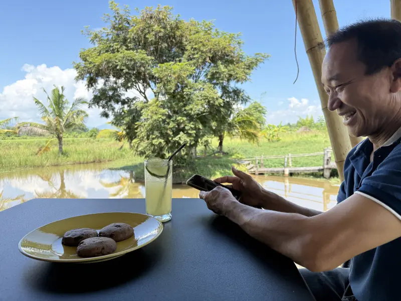 A guest drinking a lemon soda and eating a chocolate cookie with a beautiful view in the garden