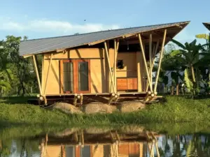 Adobe Bungalow in the evening sun at a small pond in Northern Thailand